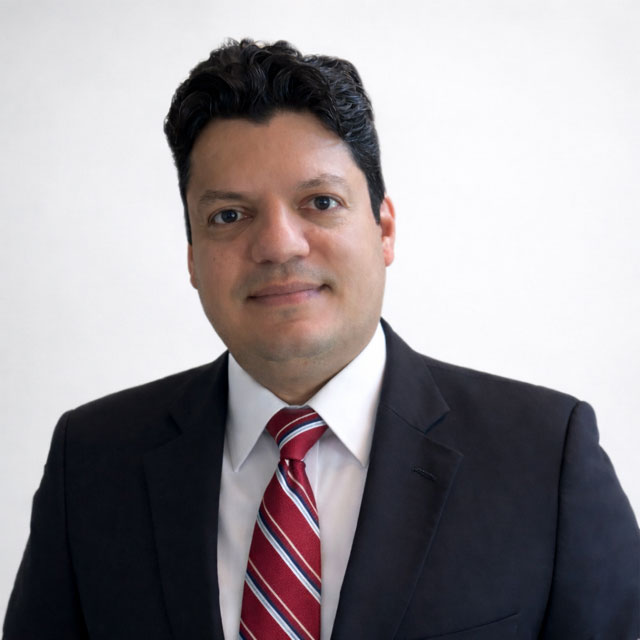 male with dark hair, blue jacket, white shirt, red tie