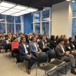 many people sitting and watching a presentation