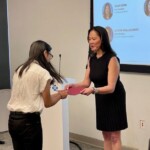woman presenting a certificate to a young adult