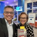 male and femal standing together holding a book