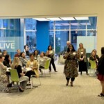 people sitting at tables listening to a speaker