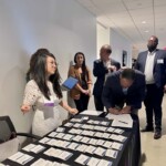 female standing at a table with name tags