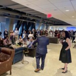 female holding microphone to speak to a group